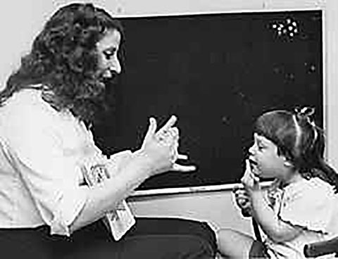 Teacher teaching girl sign language