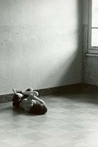 Child curled up in bare floor